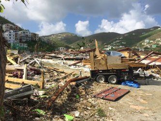 A truck is parked in the middle of a pile of rubble.