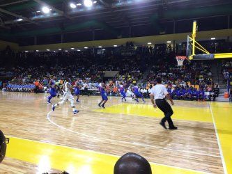 A group of people are playing basketball on a court.