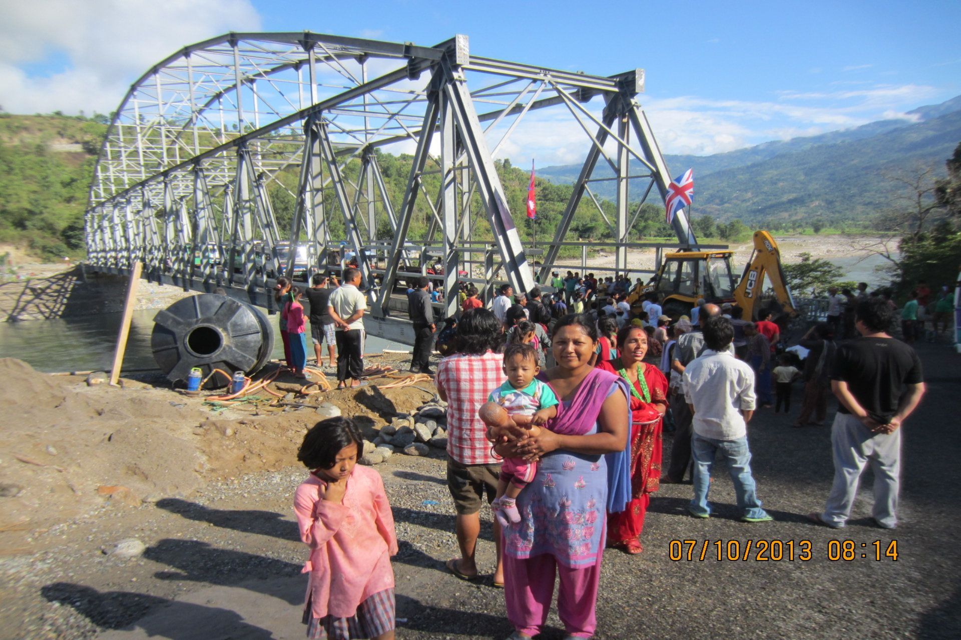 A group of people are standing in front of a bridge