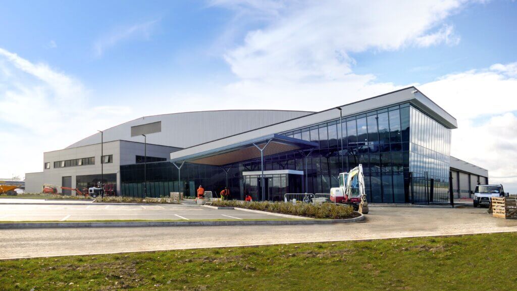 A large  Reidsteel building with a lot of windows and a truck parked in front of it.