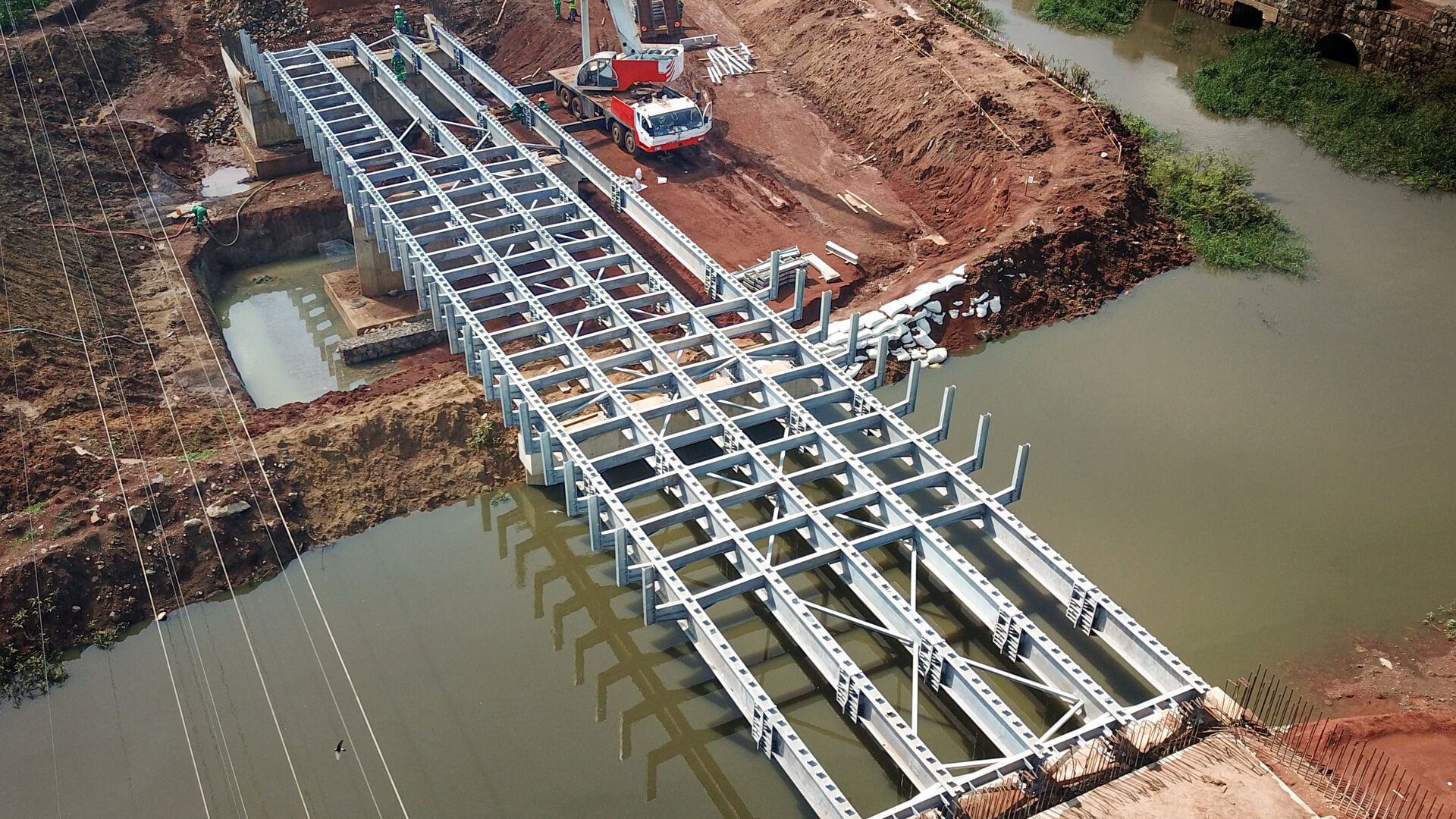 An aerial view of a bridge being built over a river.