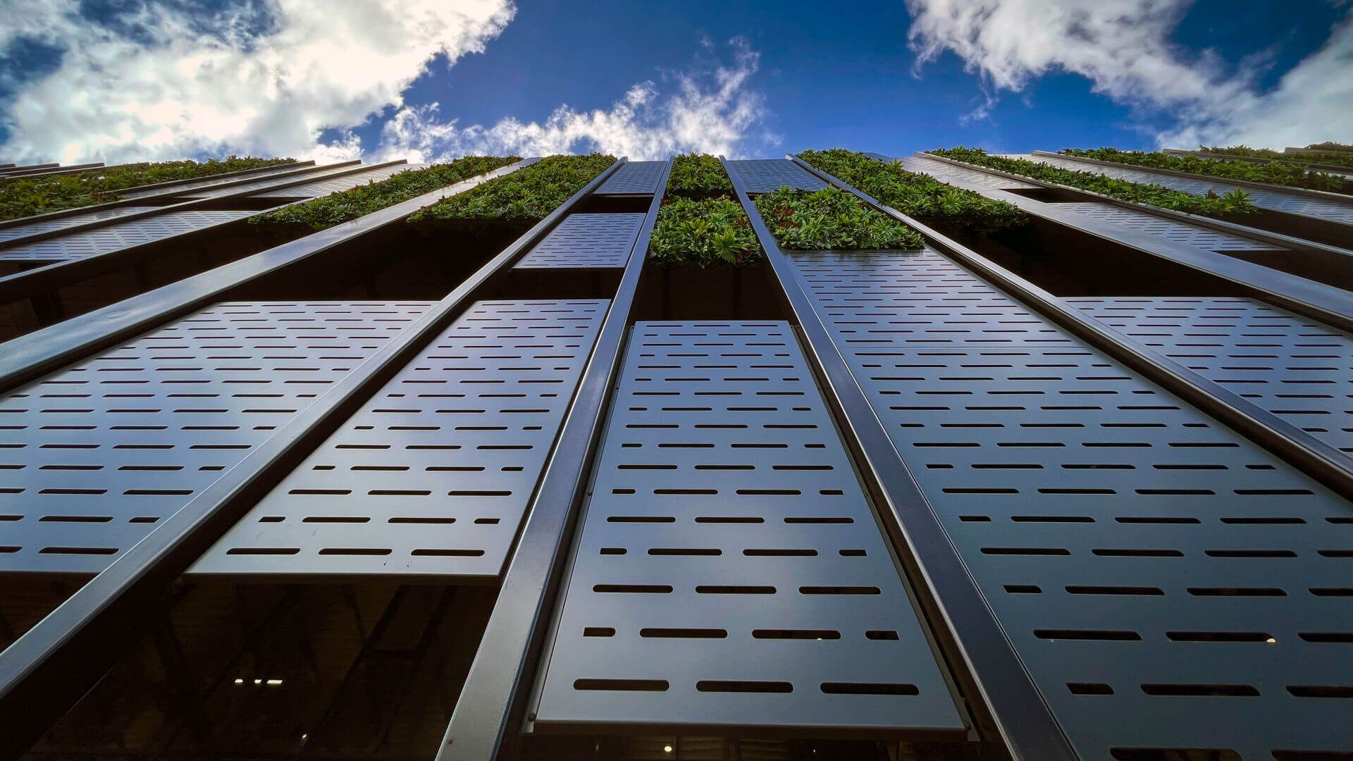 Looking up at a tall  Reidsteel building with a blue sky in the background.