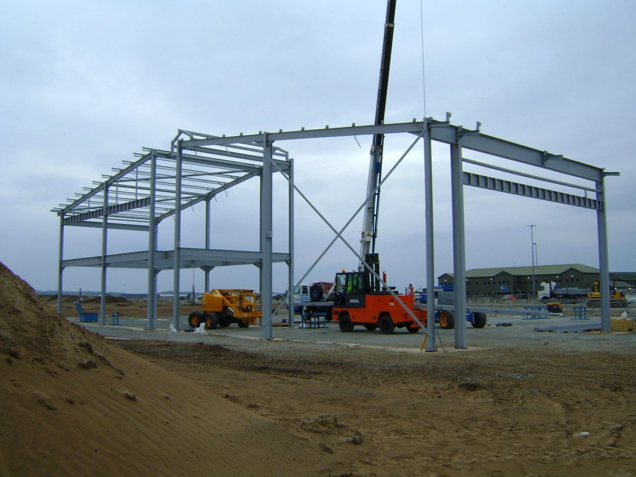 A large metal structure is being built with a crane