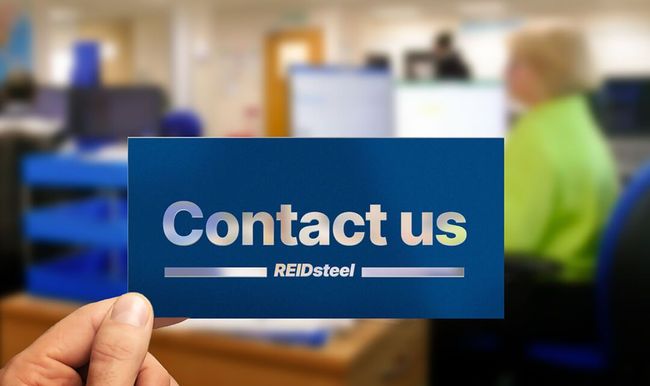 A person is holding a card that says contact us in front of a group of people.