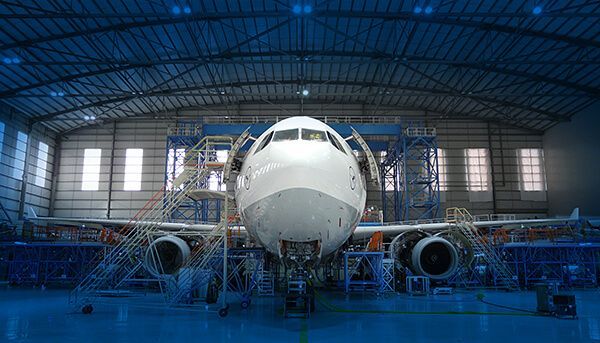 An airplane is being built in a hangar.