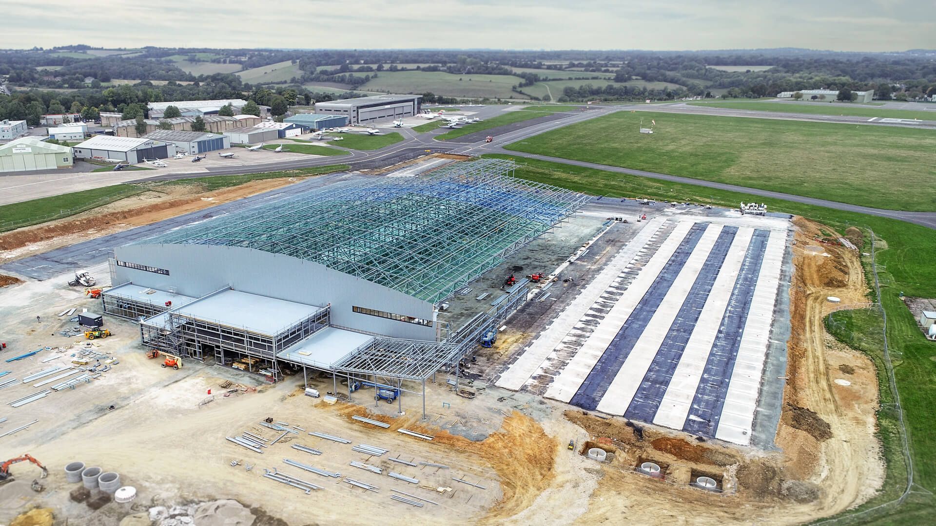 An aerial view of a large building under construction in a field.