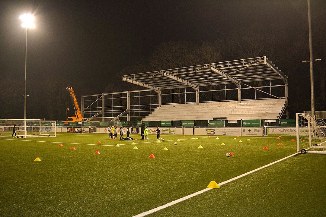 A soccer field with a stadium in the background