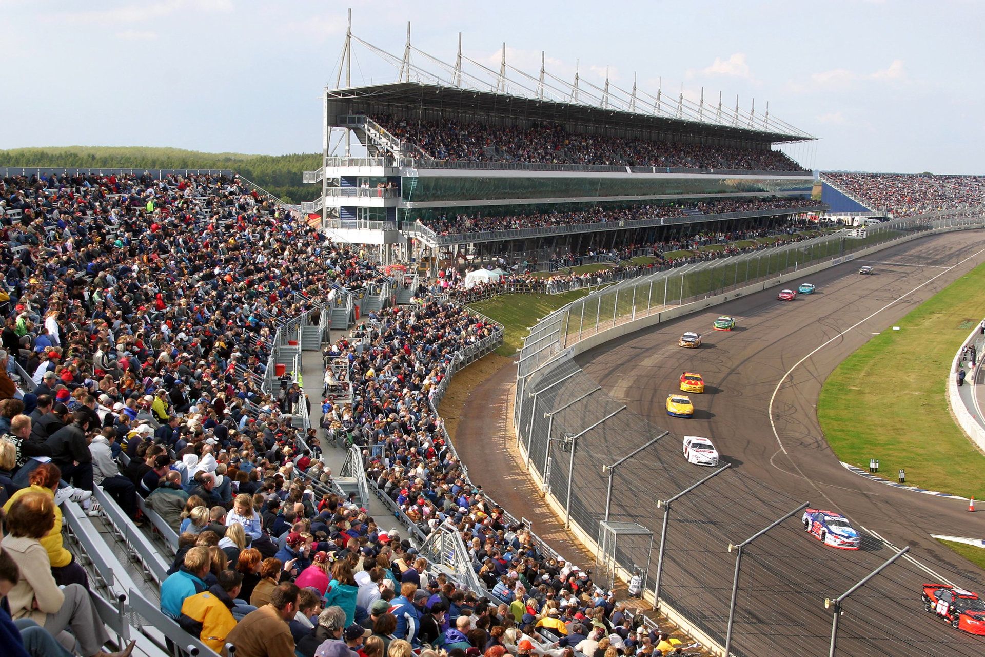 A crowd of people are watching a race at a race track