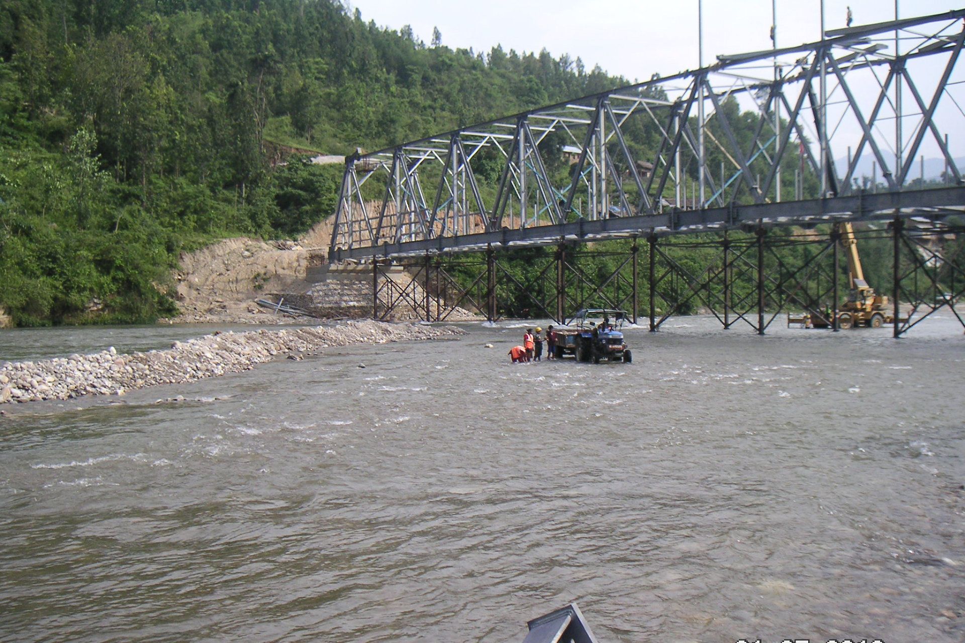 A bridge over a river with a car in the water