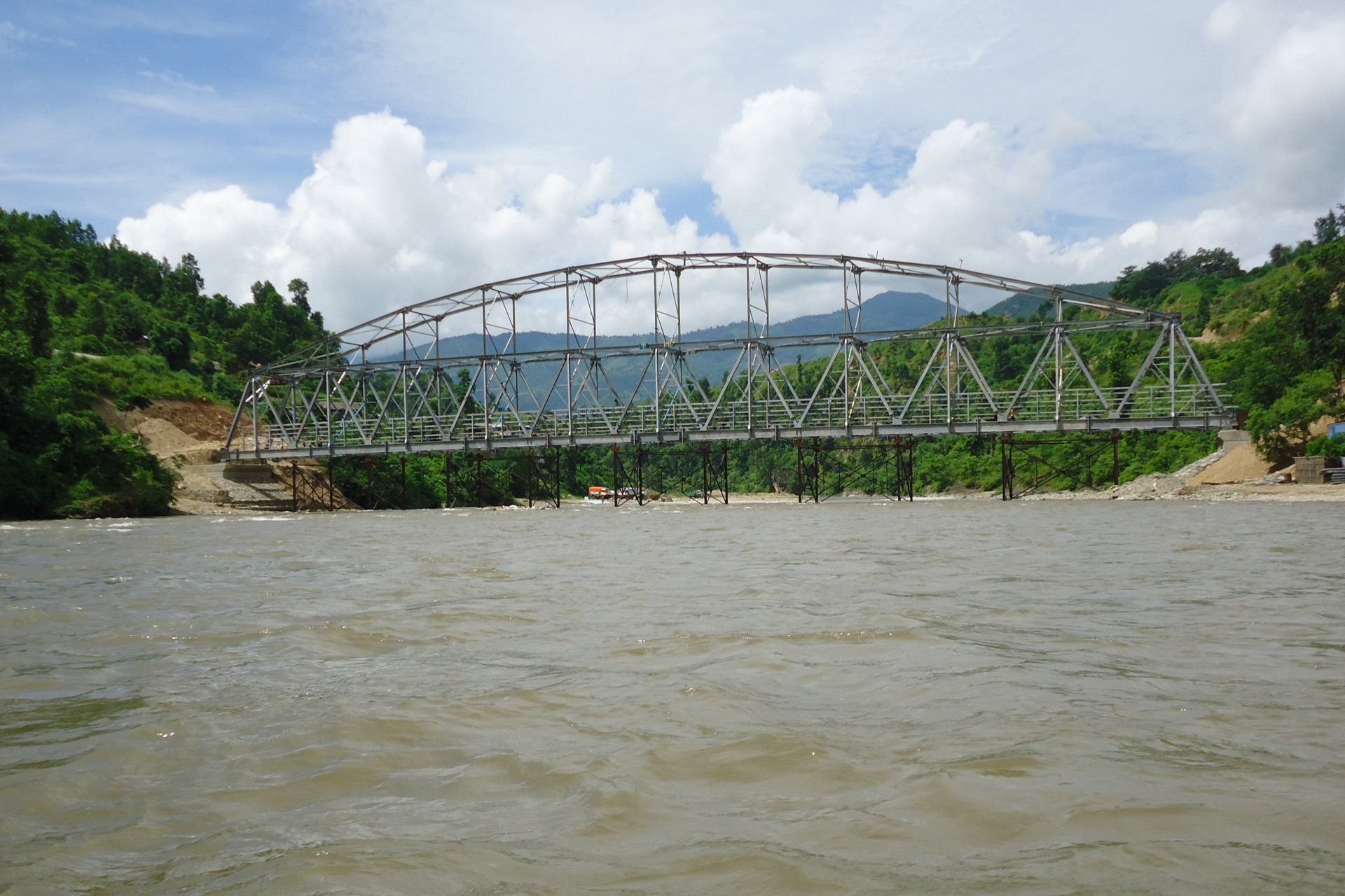 A bridge over a river with mountains in the background