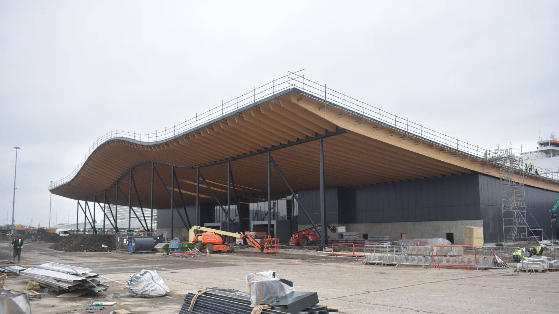A large building is being built with a wooden roof.