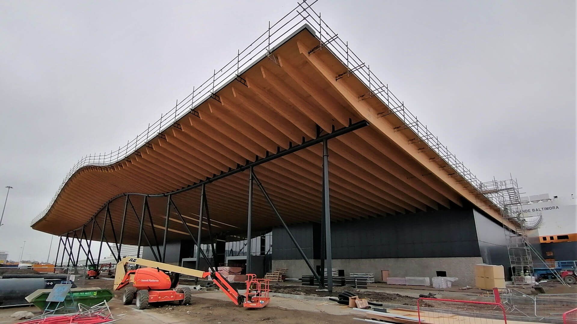 A large building under construction with a large wooden roof.