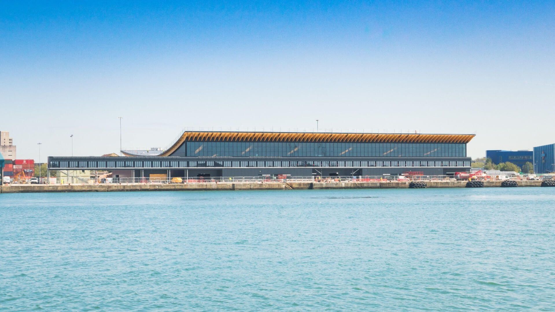 A large cruise terminal building is sitting next to a body of water.