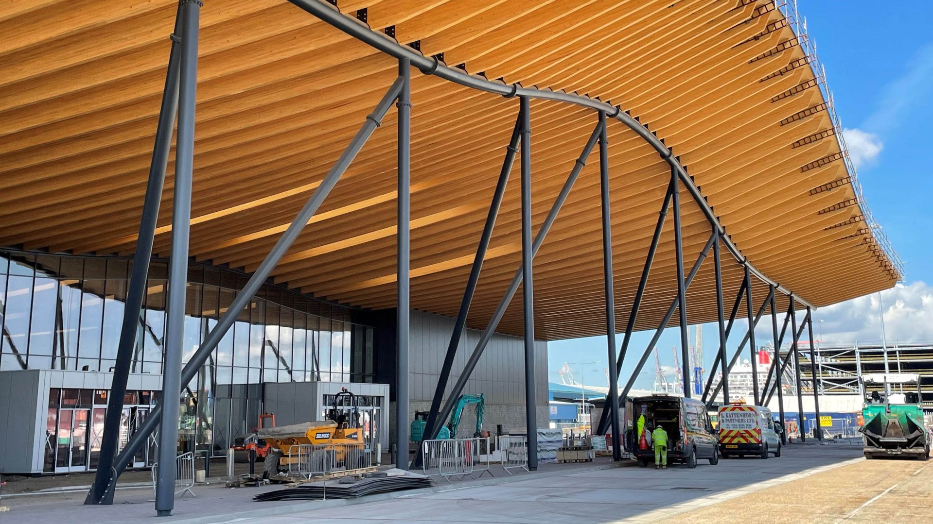 A large building with a wooden roof is being built.