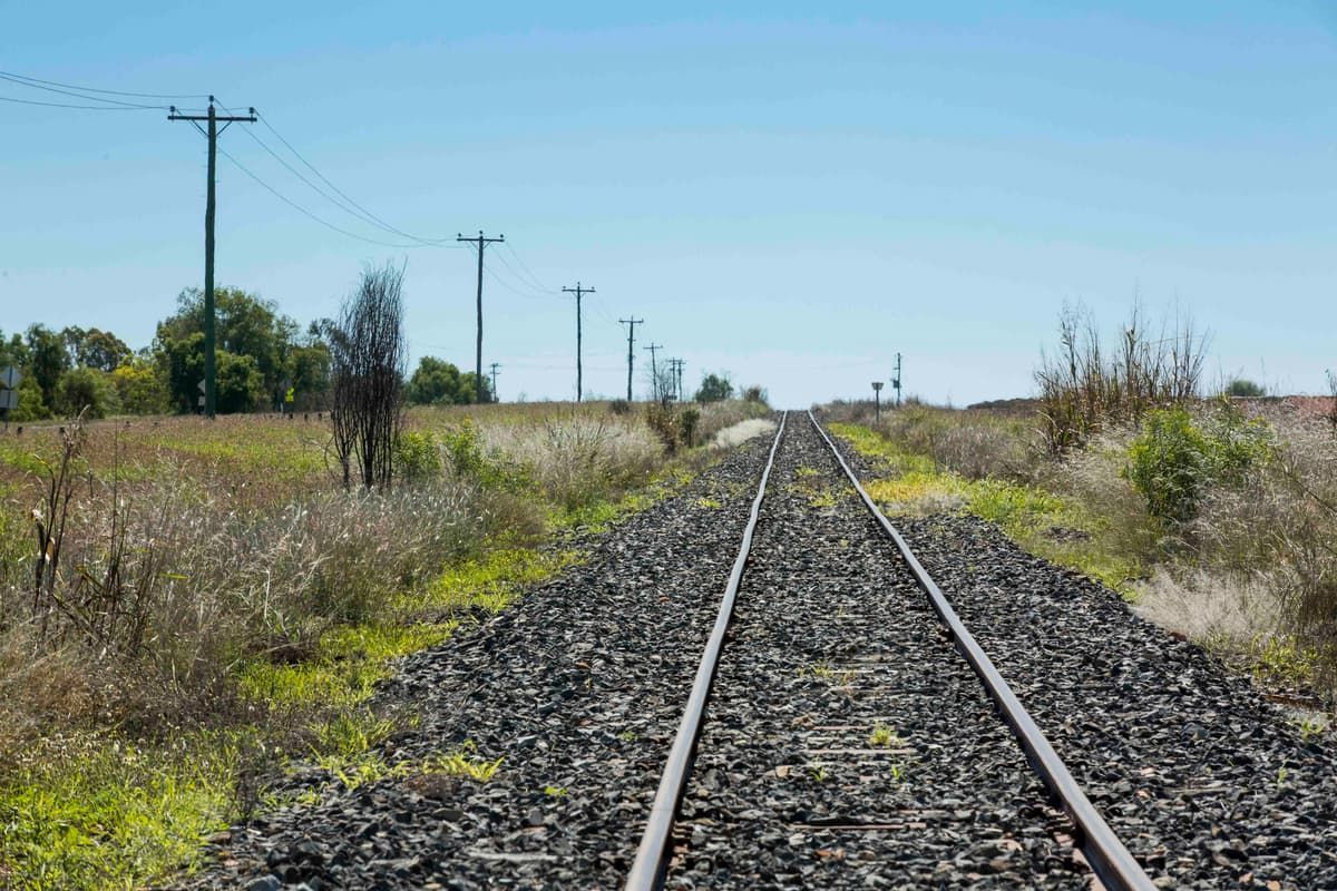 Train Track Going Through a Grassy Field With Power Lines — MFM Soil Solutions in Emerald, QLD