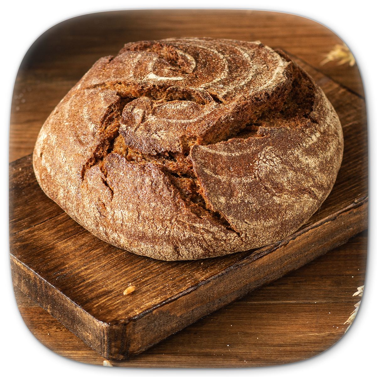 Round loaf of dark, crusty bread on a wooden cutting board.