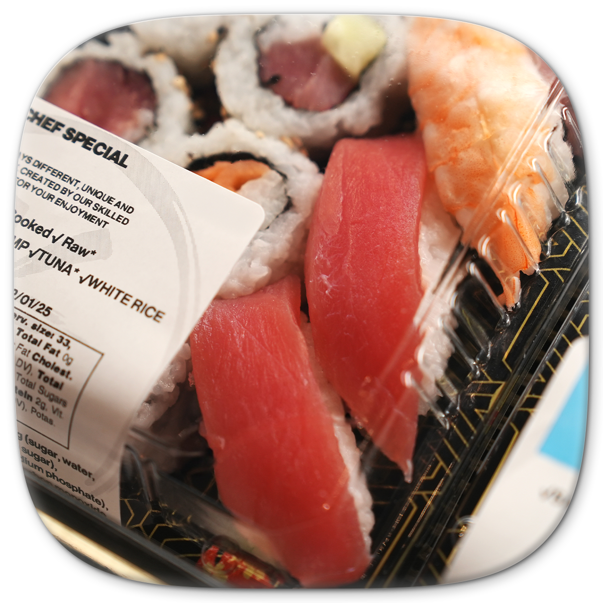Sushi assortment in a clear plastic container, including rolls and nigiri with tuna and shrimp.