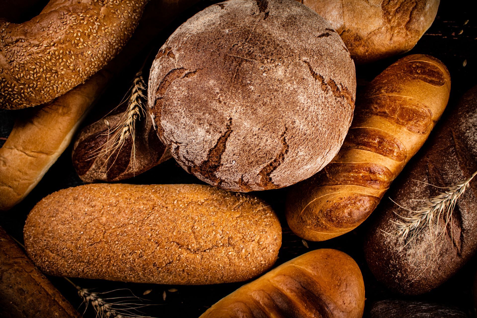 Assorted loaves of bread, various shapes and sizes, overhead view.