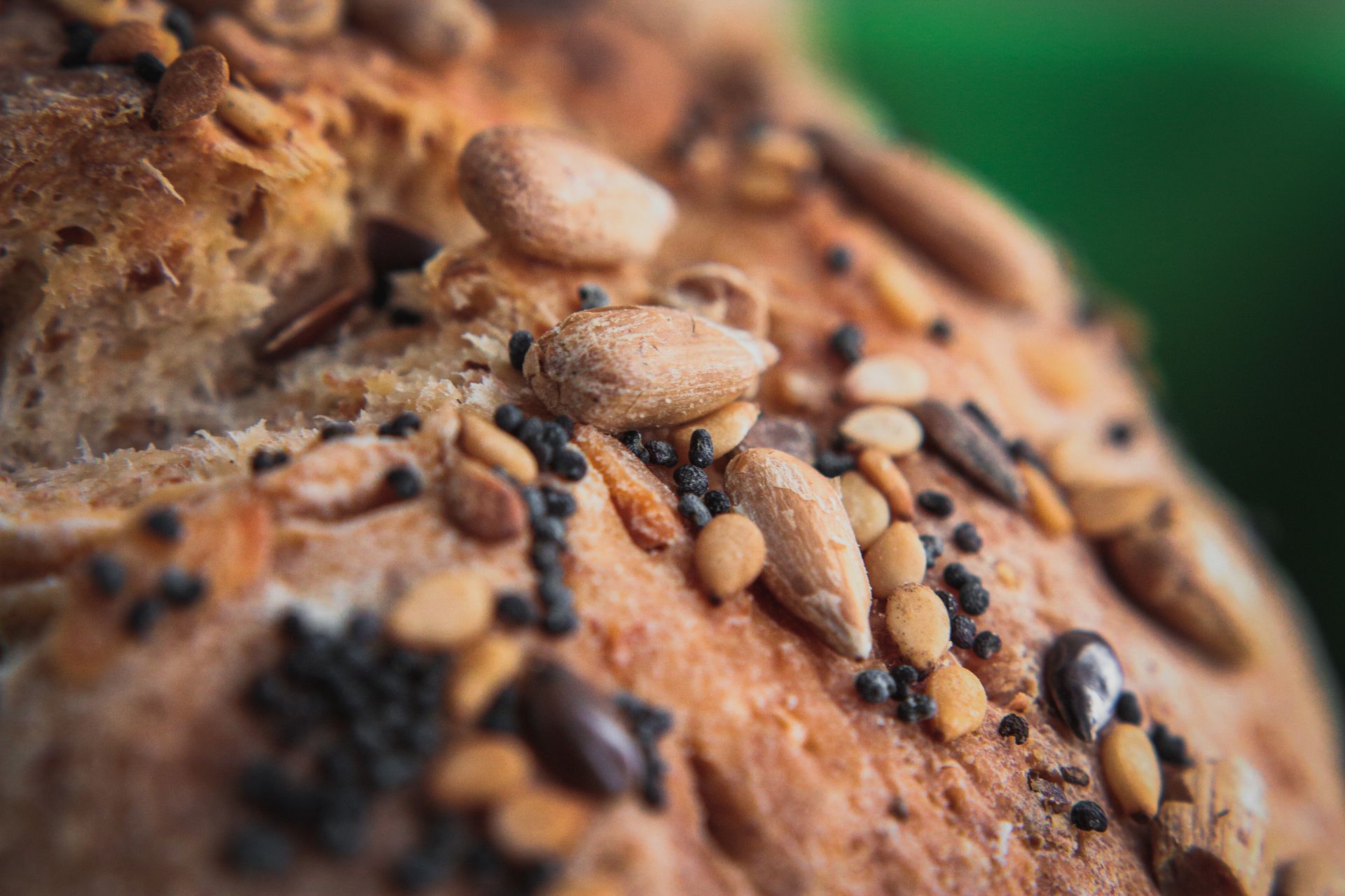 Close-up of a crusty bread loaf speckled with various seeds.