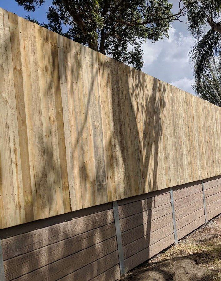 Lizard Skin Woodgrain Concrete Sleeper Retaining Wall with Timber Fence - Residential — in Gold Coast, QLD