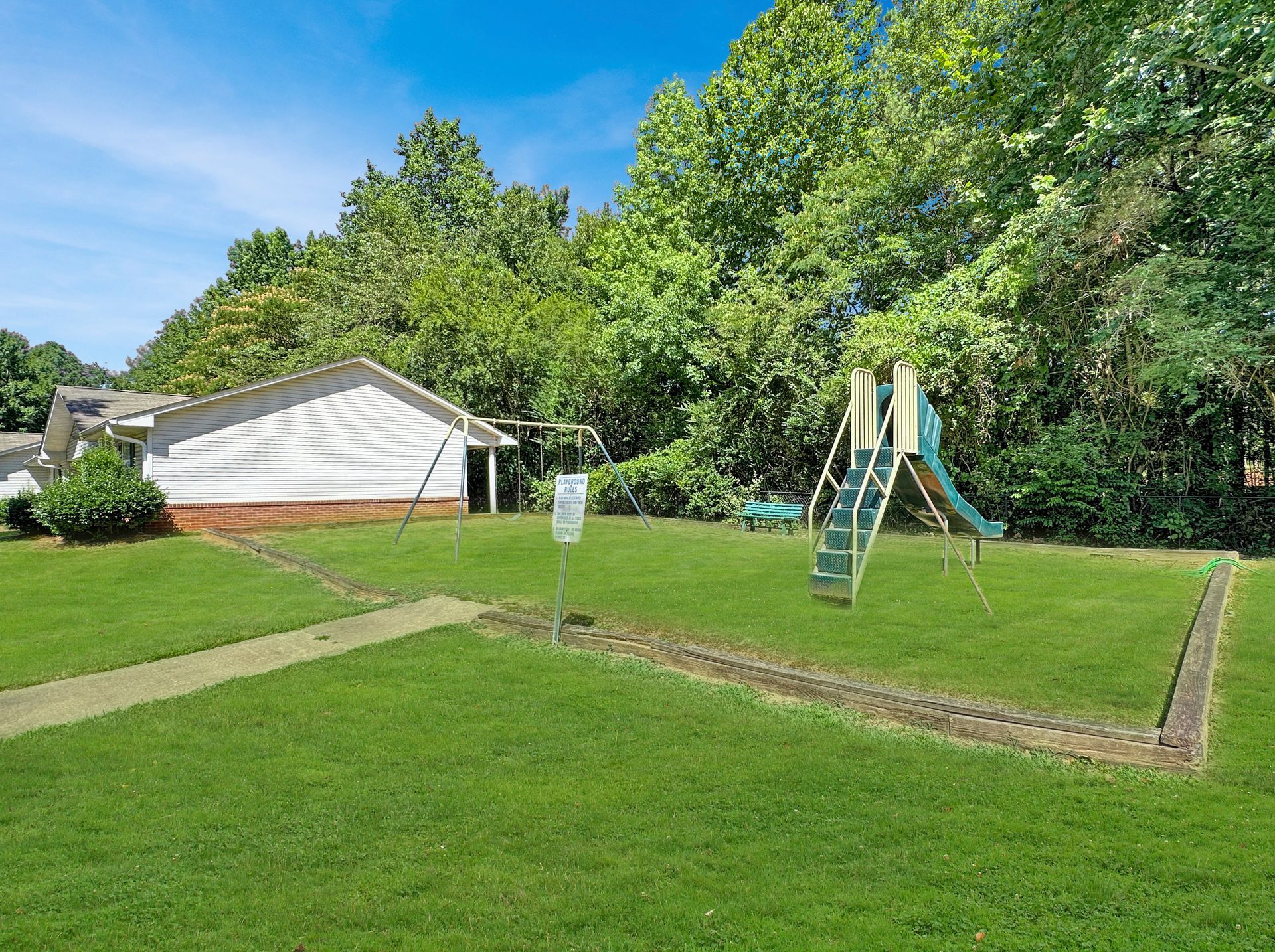 There is a playground in the backyard of a house.