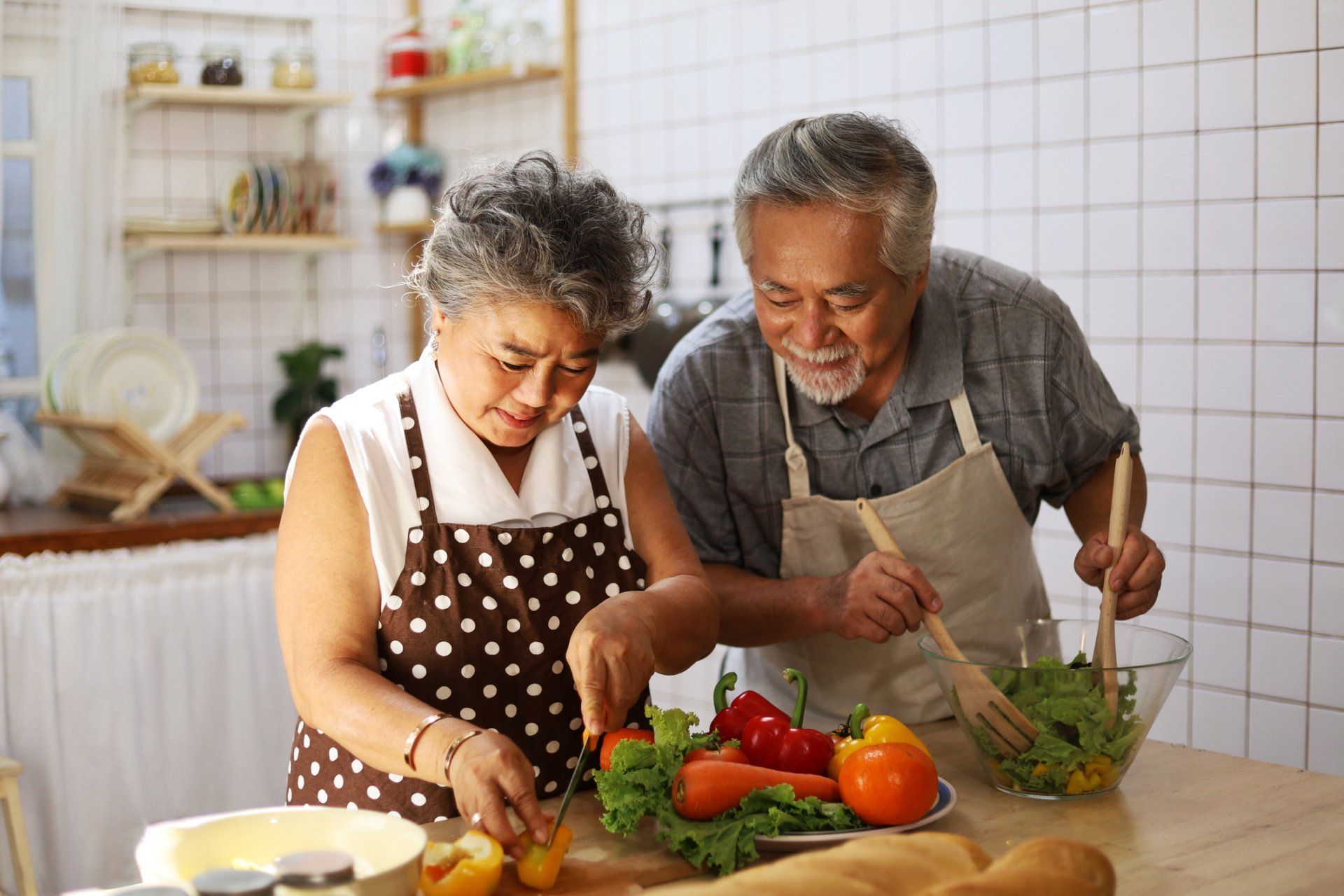 A man and a woman are preparing food in a kitchen.