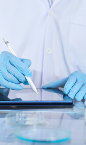 Un científico con guantes azules está usando una tableta.