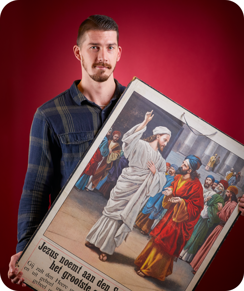 Portret van Jordy van der Heijden met het grootste gebod der wet op een plaat in z'n hand