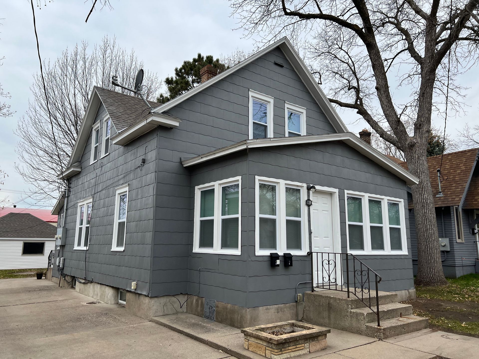 A gray house with a lot of windows and stairs