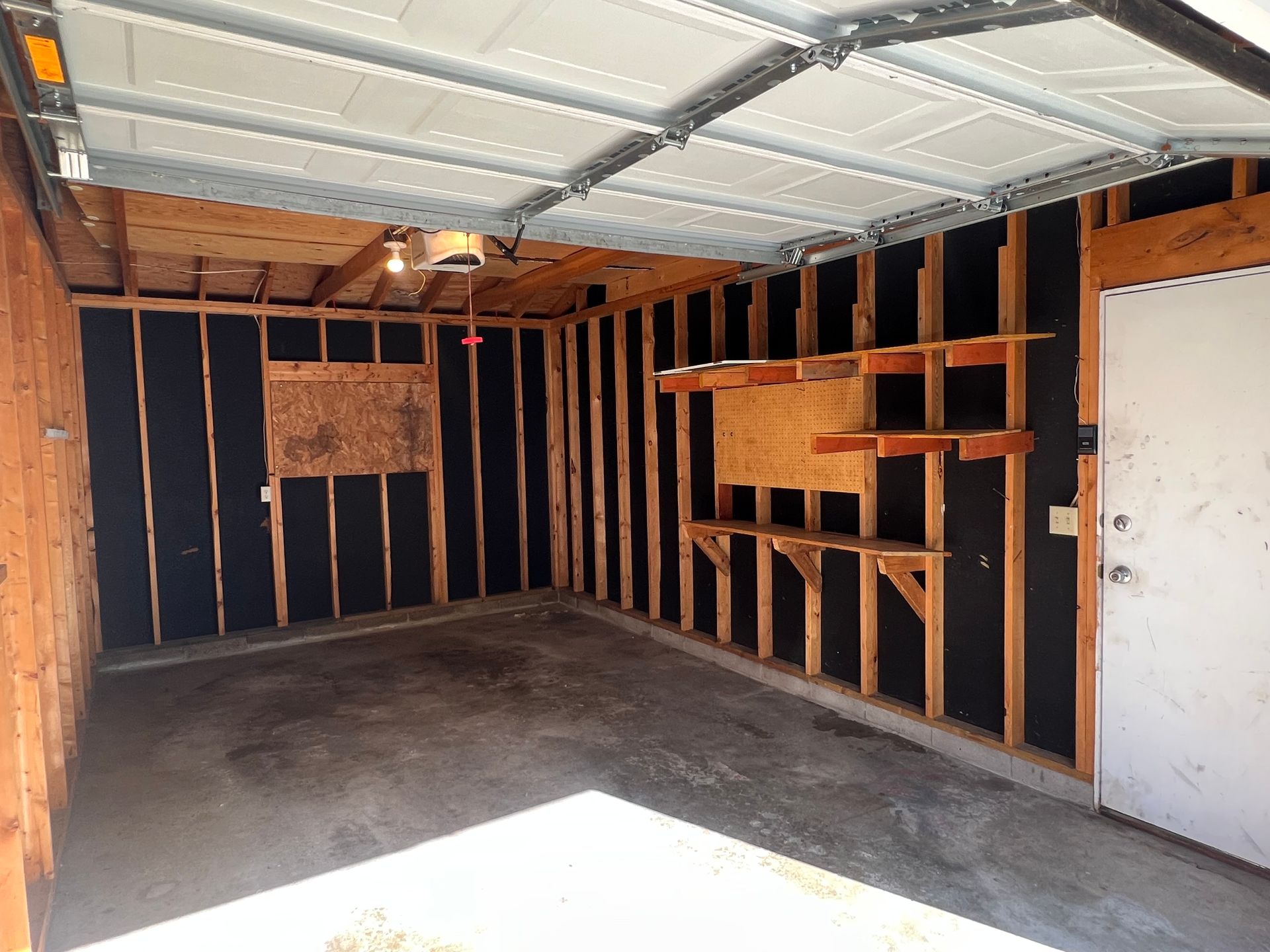 The inside of a garage with a garage door open