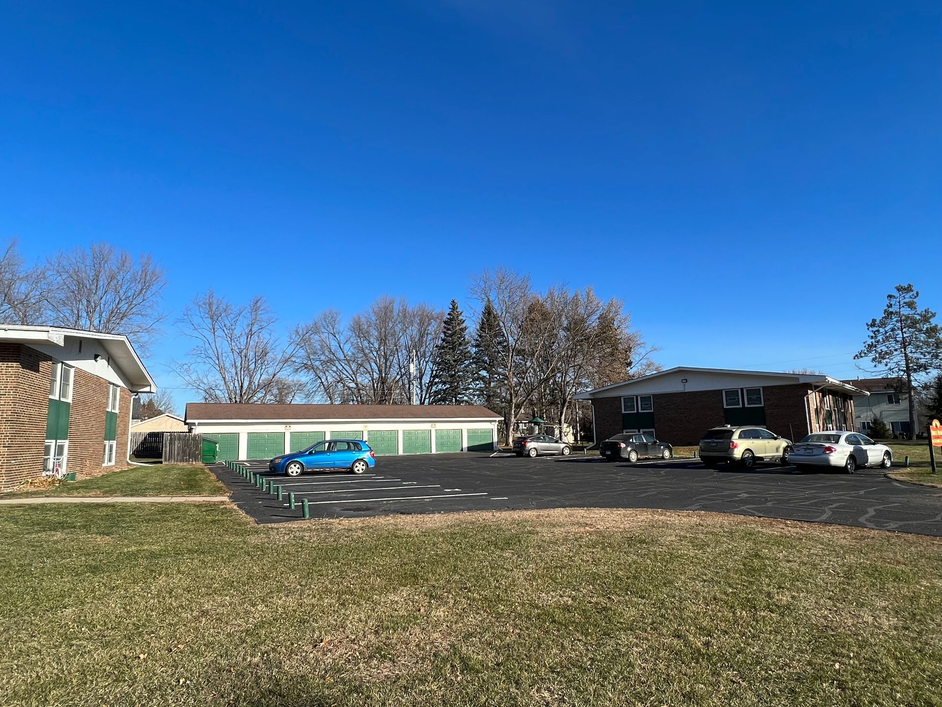 A parking lot with cars parked in front of a building.