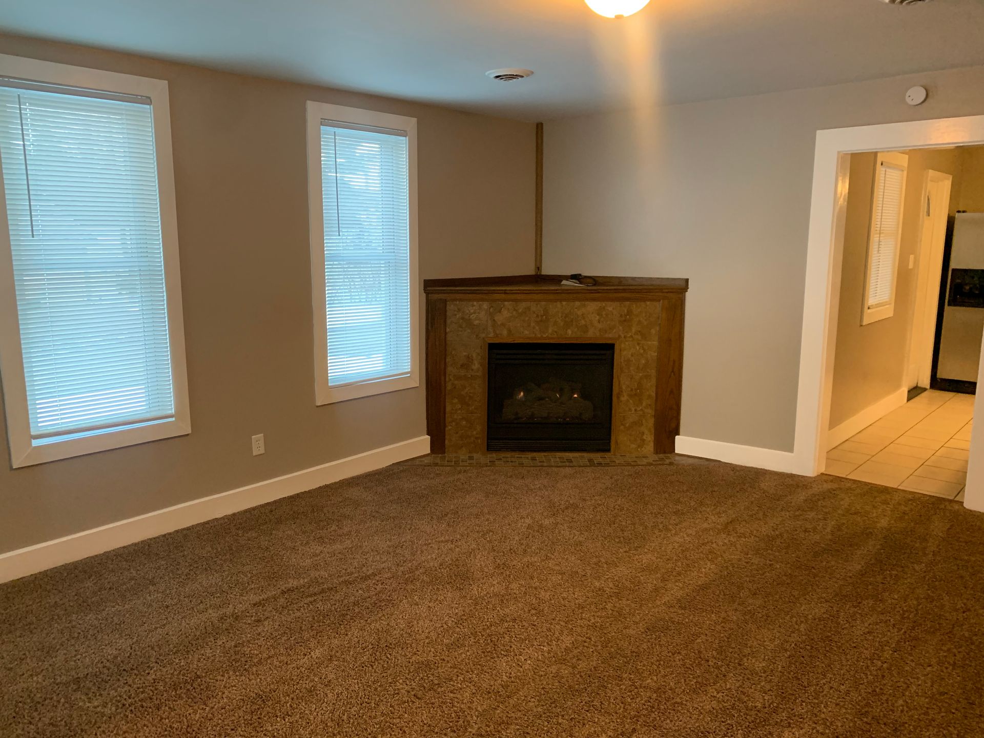 There is a fireplace in the corner of the living room.