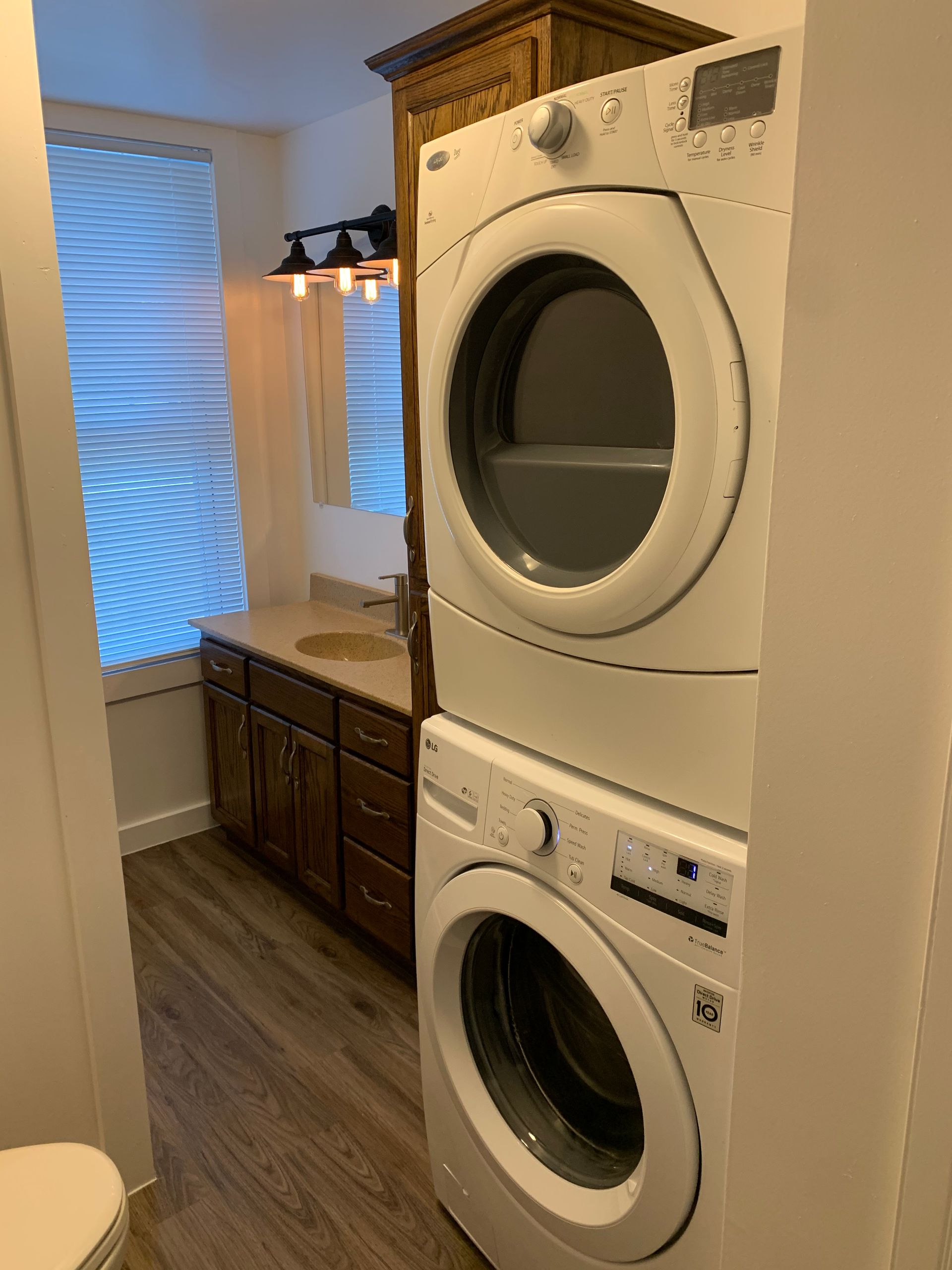 A bathroom with a washer and dryer stacked on top of each other.