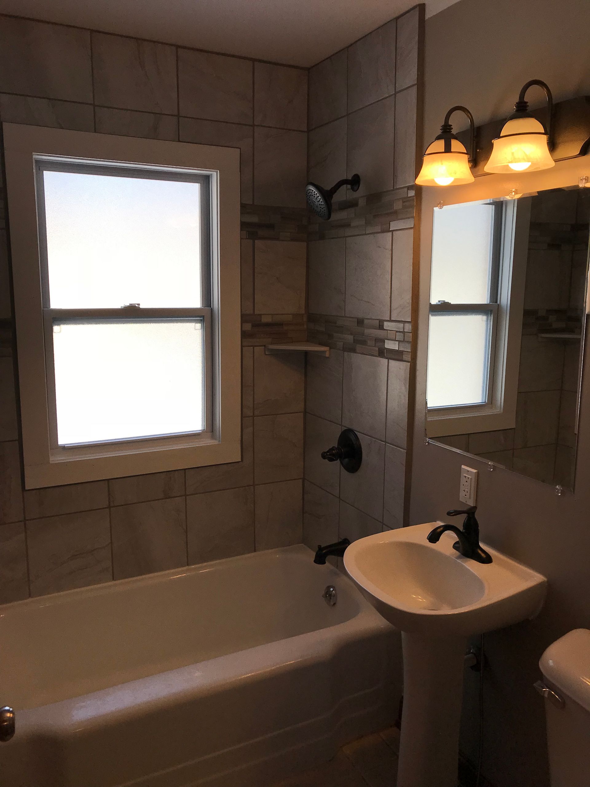 A bathroom with a sink a tub and a window