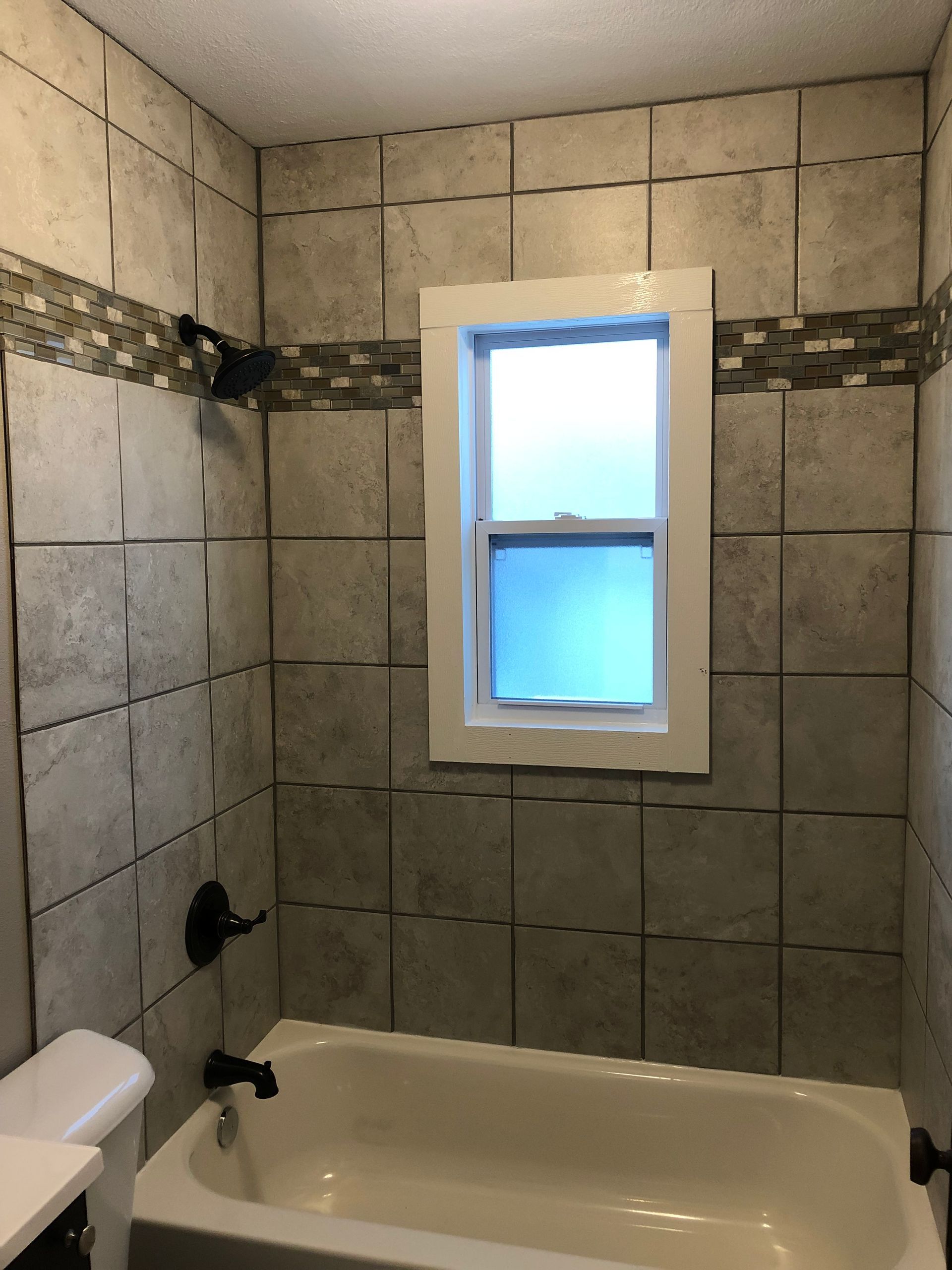 A bathroom with a bathtub and a window