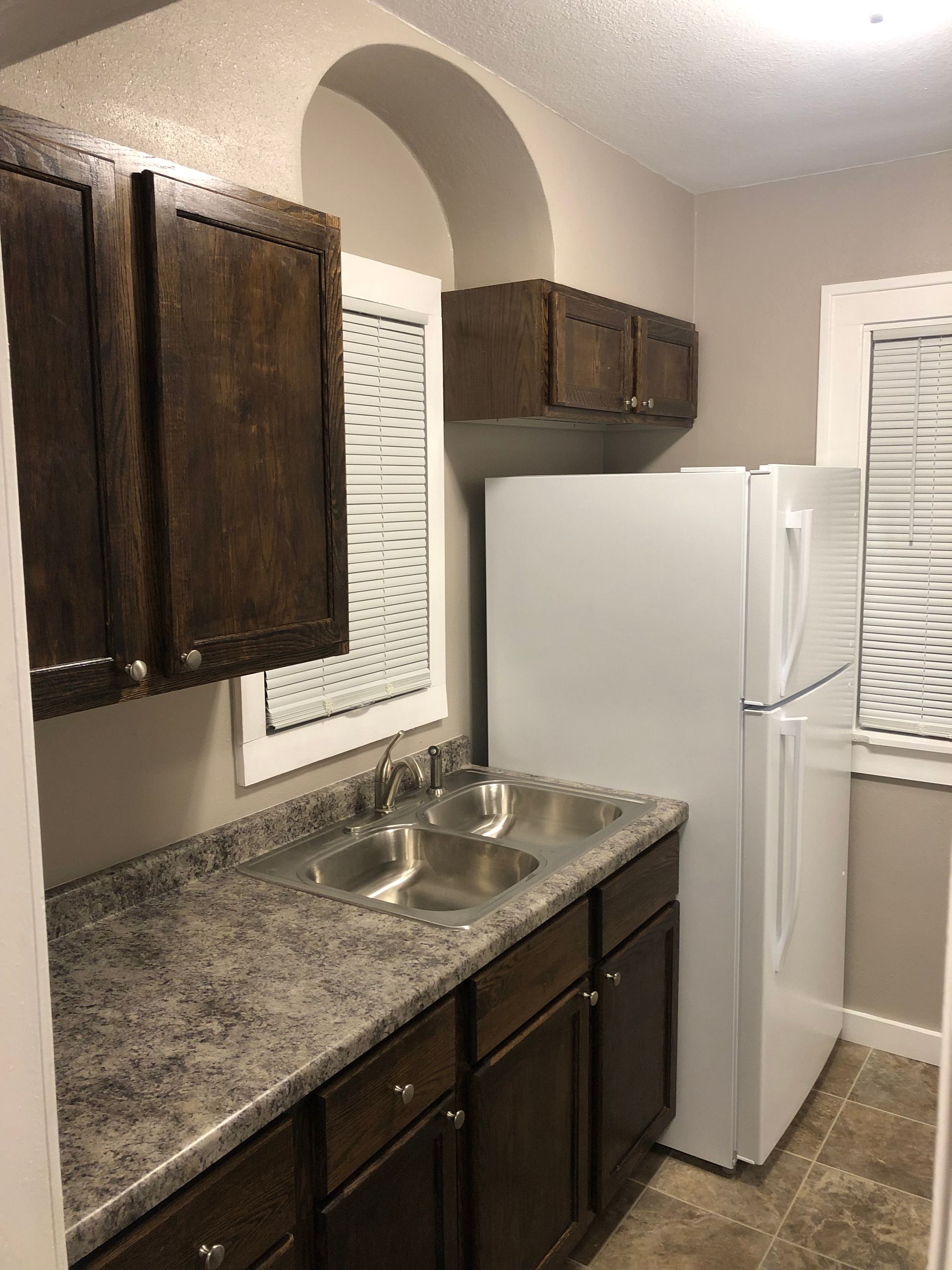 A kitchen with two sinks and a refrigerator