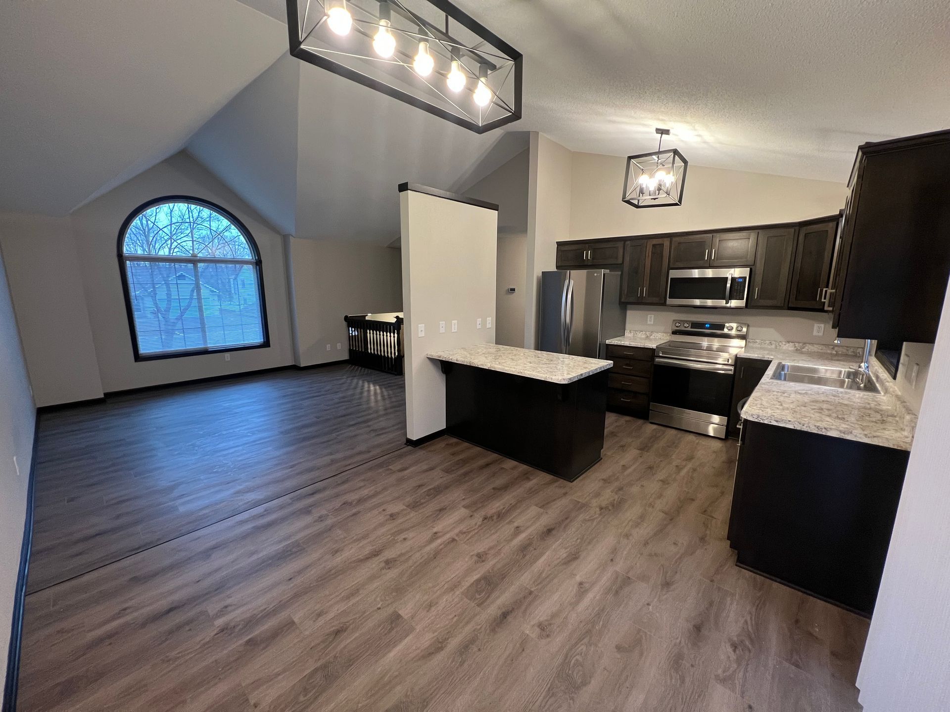 A kitchen with stainless steel appliances and a large window.