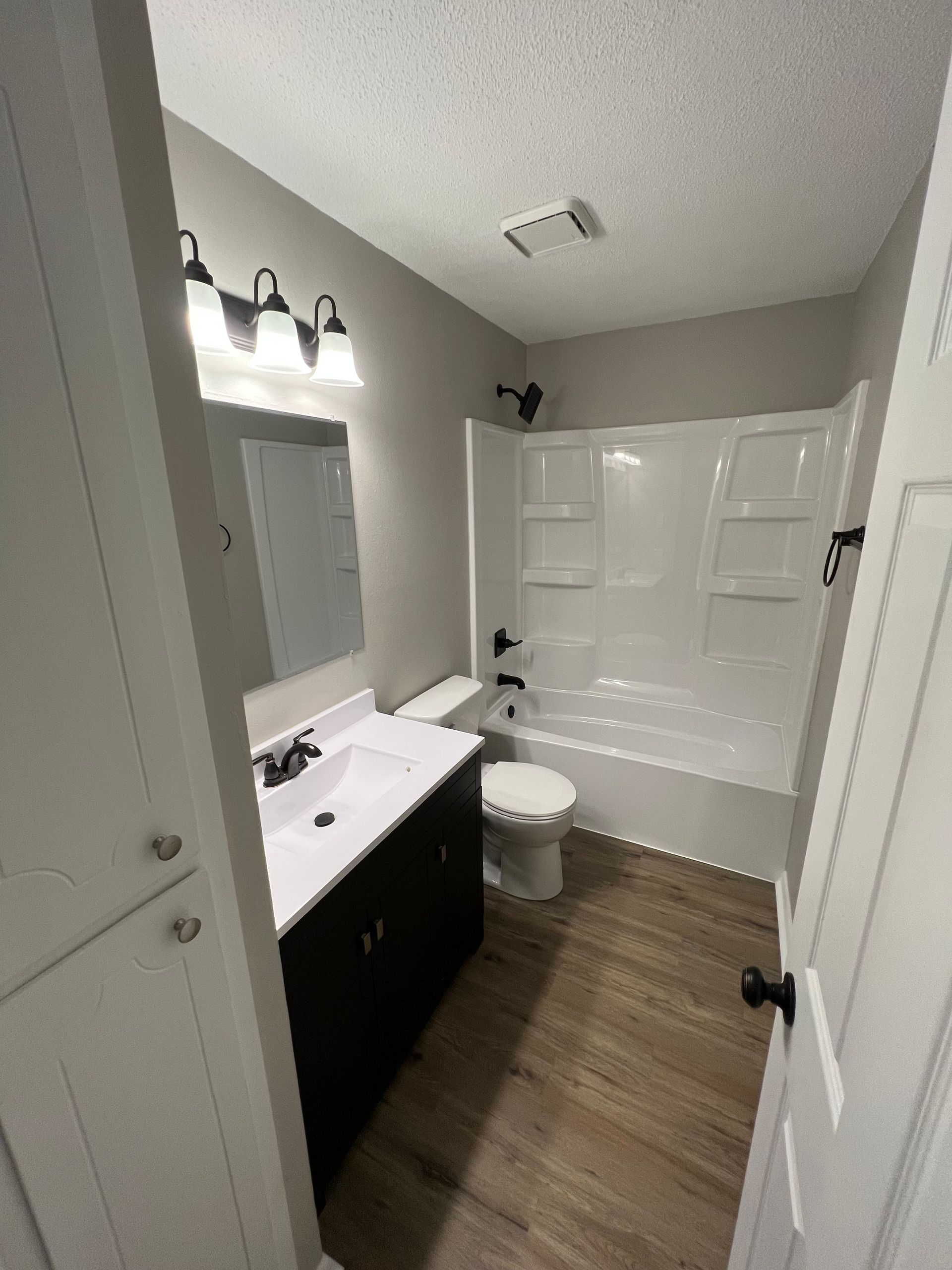 A bathroom with a sink , toilet , bathtub and mirror.