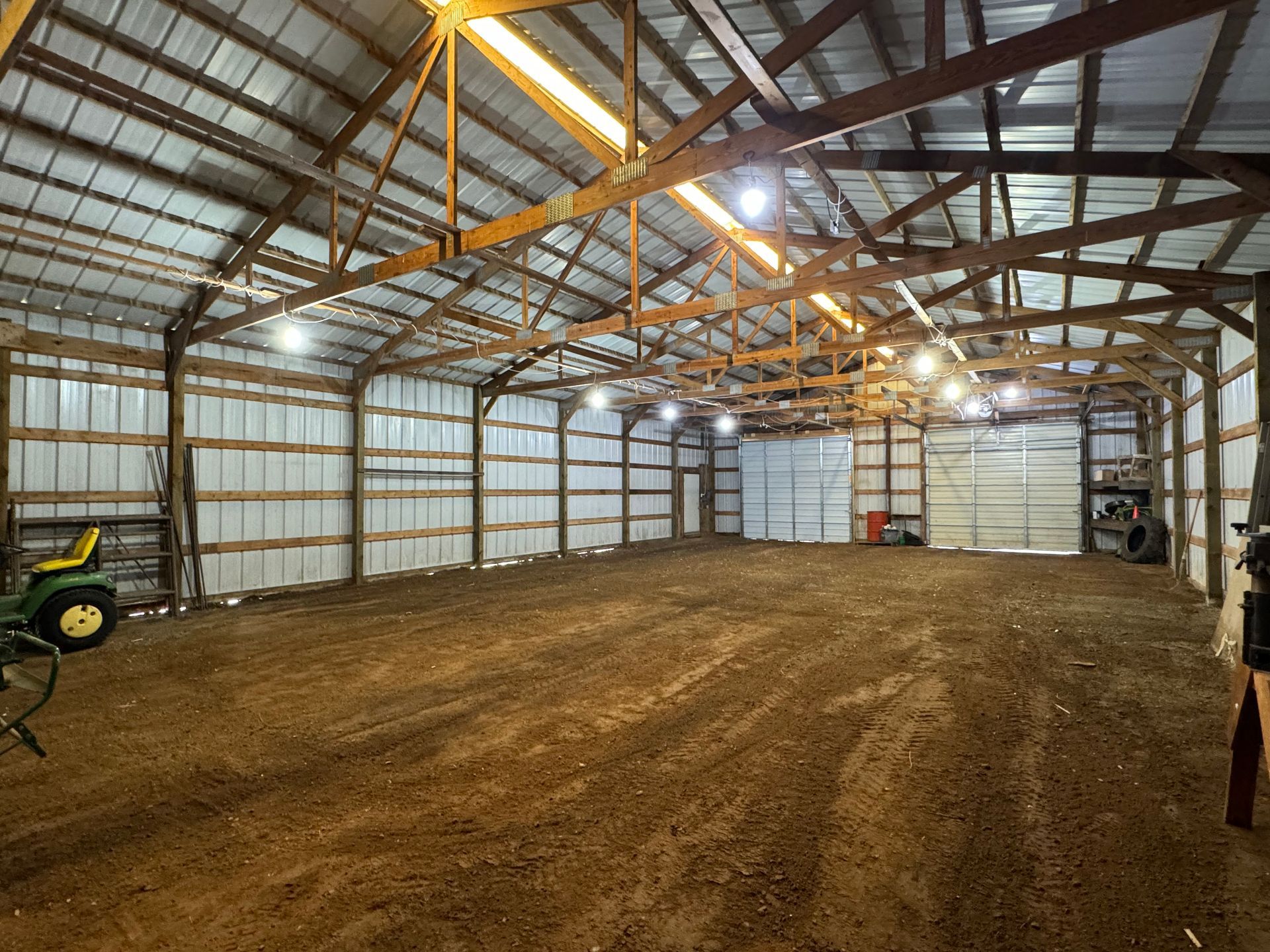 A large empty barn with a tractor parked inside of it.