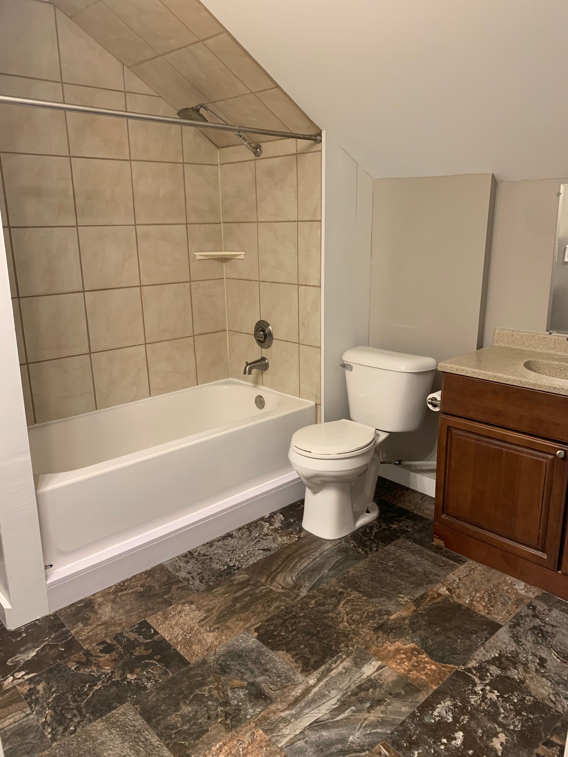 A bathroom with a toilet , sink and bathtub.