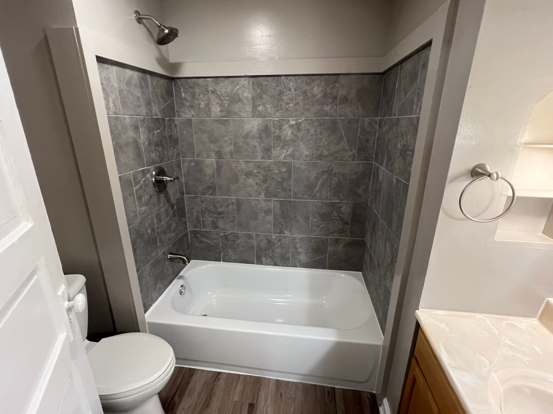 A bathroom with a bathtub , toilet , sink and shower.