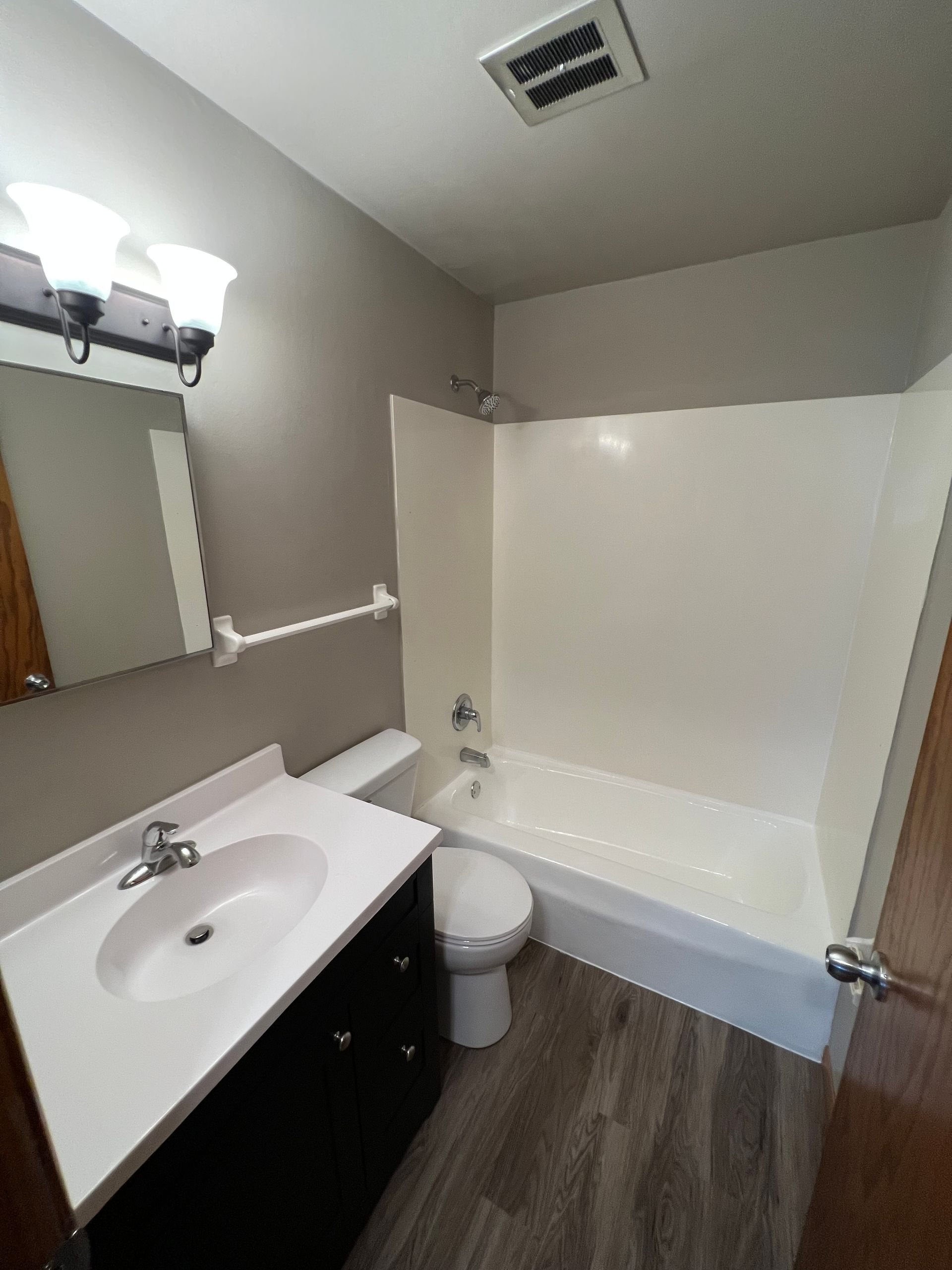 A bathroom with a sink , toilet , bathtub and mirror.