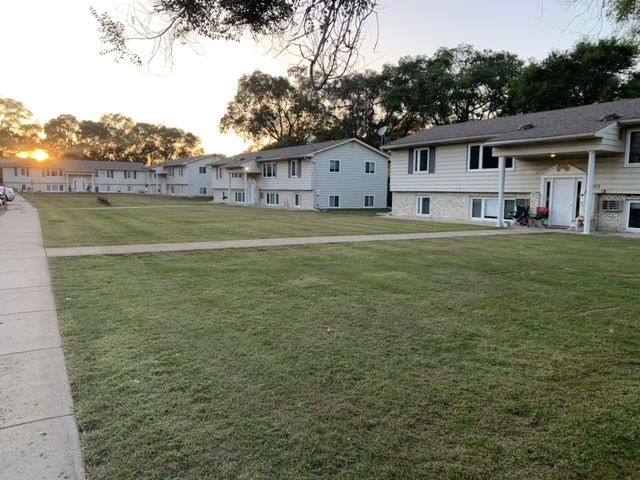 A row of houses with a large lawn in front of them
