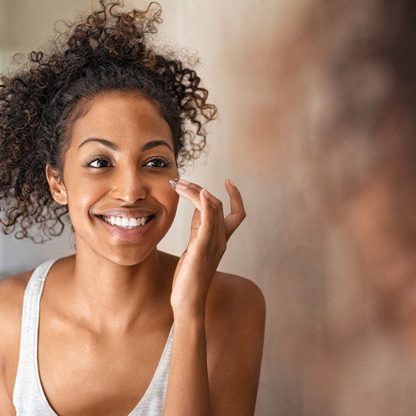 Woman Applying Facial Cream — Metairie, LA — Dr. Carter D. Paddock