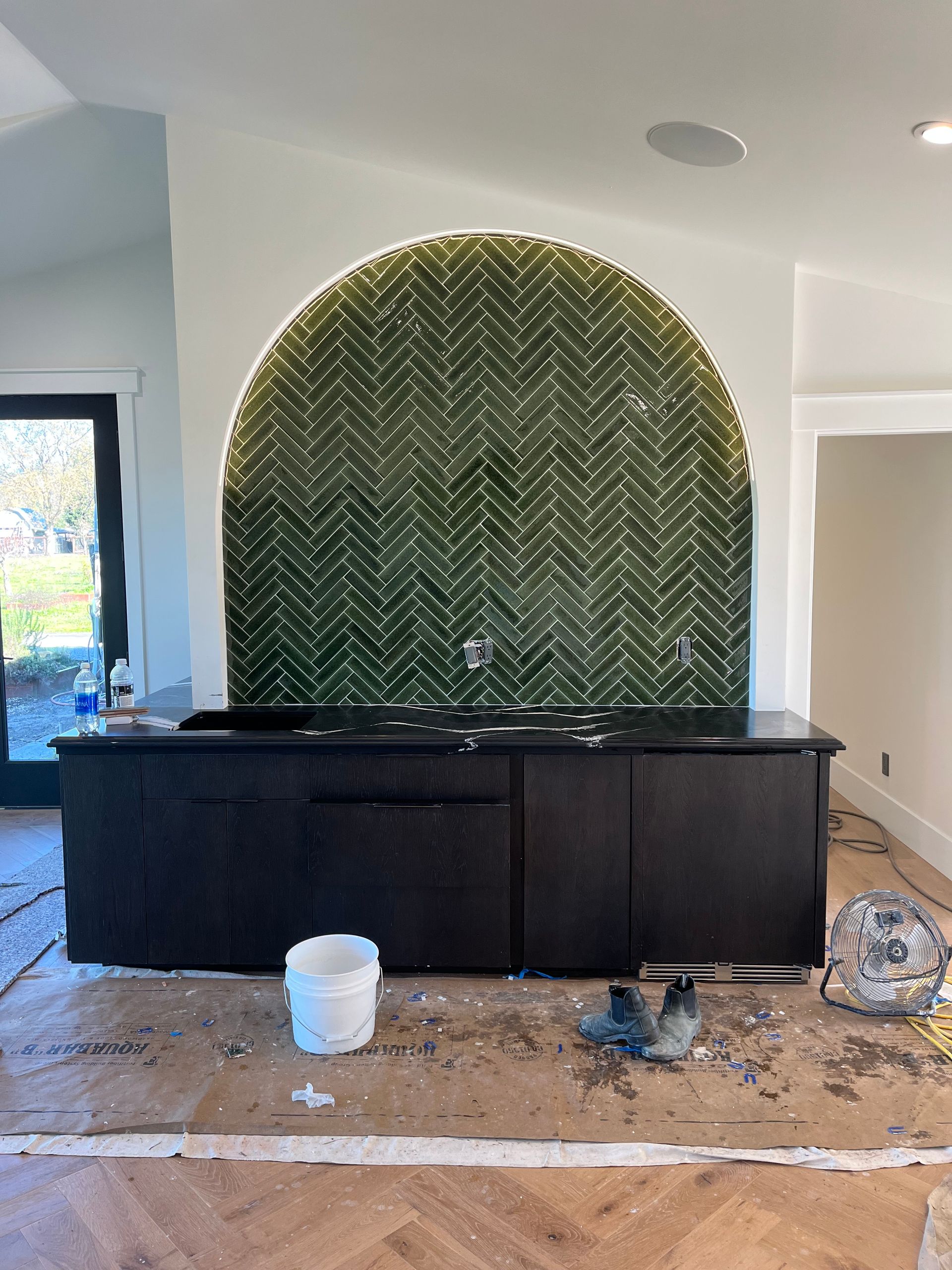 Contractor installing floor tiles in a newly constructed house.