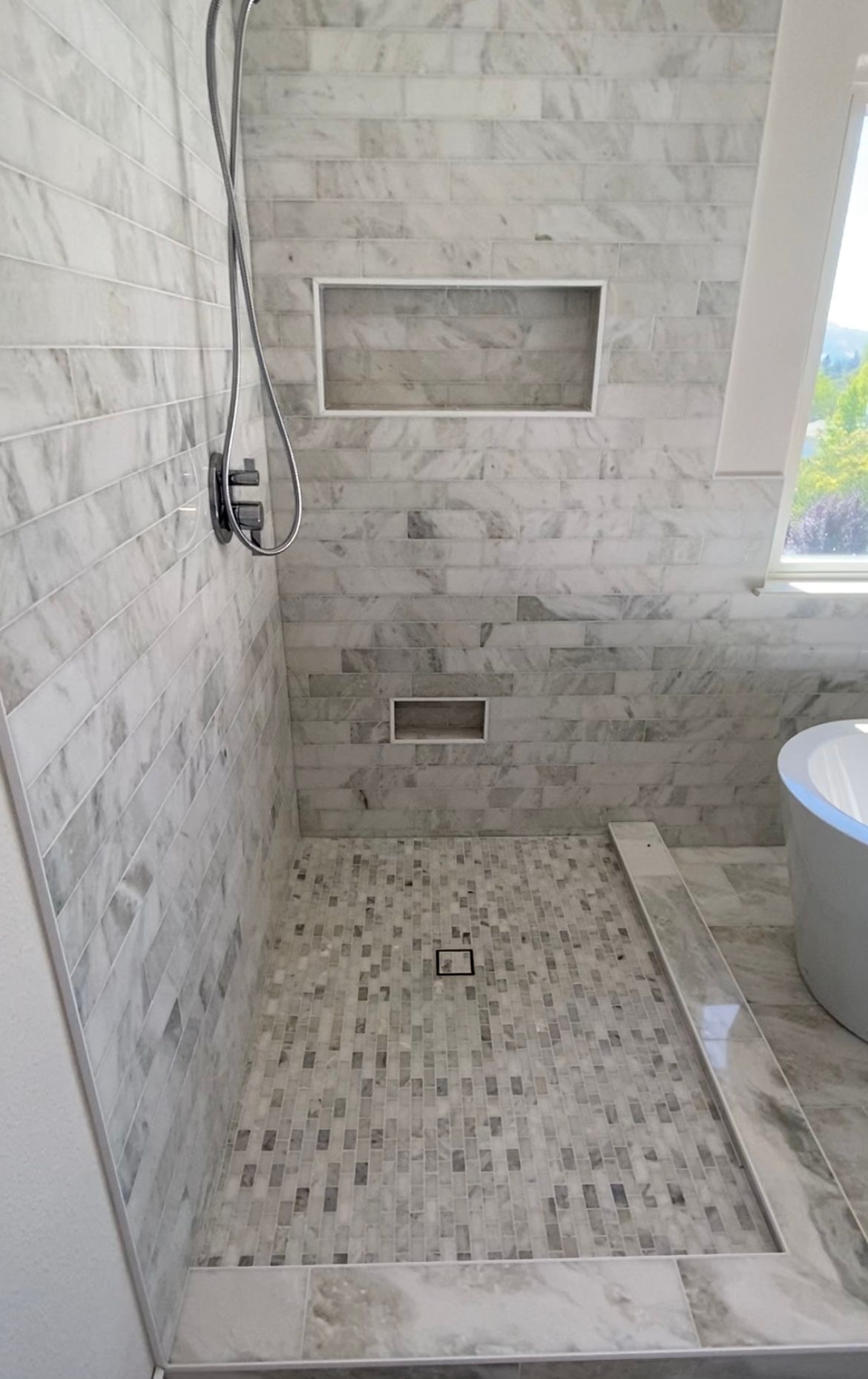 A person carefully installing ceramic tiles on a floor, creating a beautiful tiled surface.