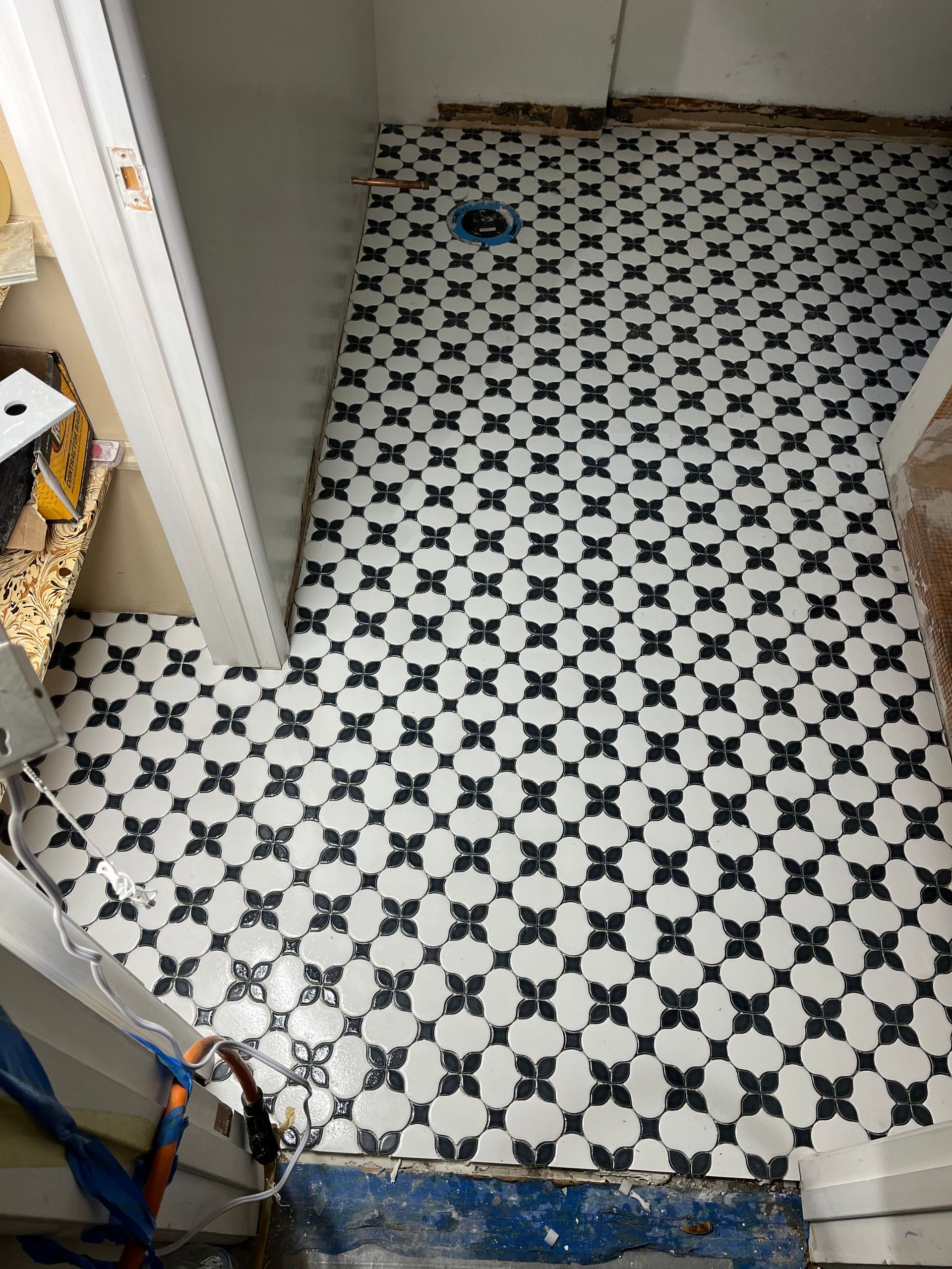 A person carefully installing ceramic tiles on a floor, creating a beautiful tiled surface.