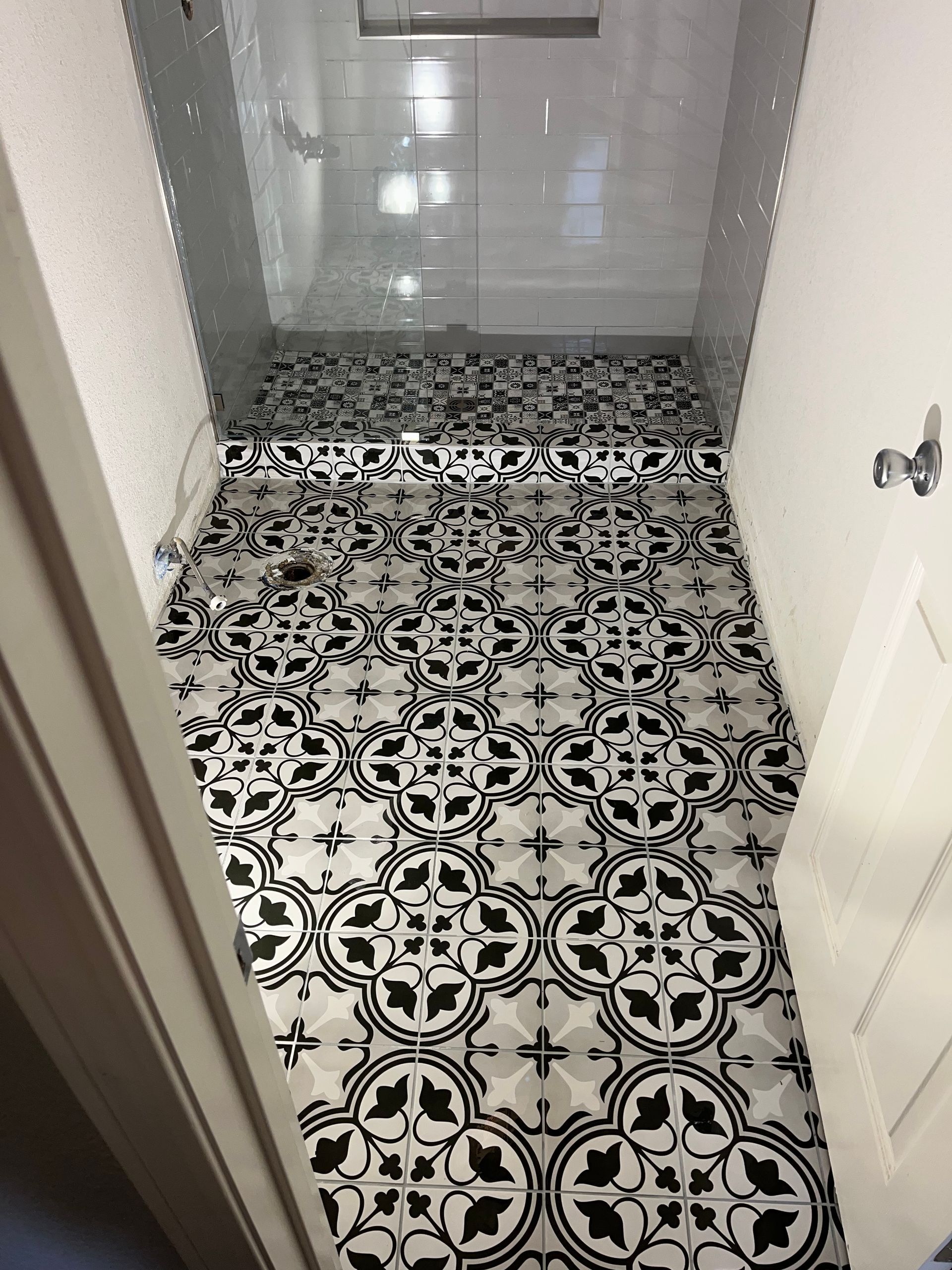 Contractor installing floor tiles in a newly constructed house.