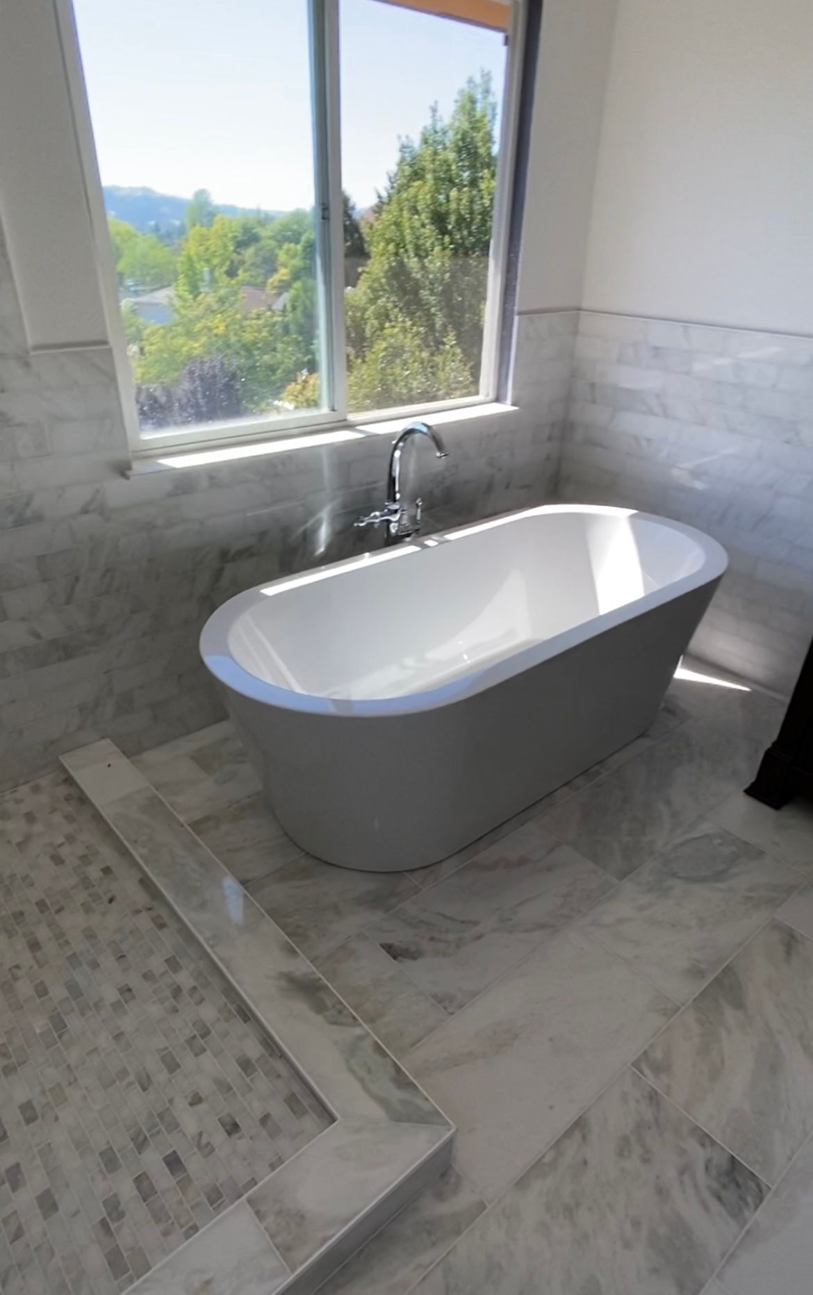 Contractor installing floor tiles in a newly constructed house.