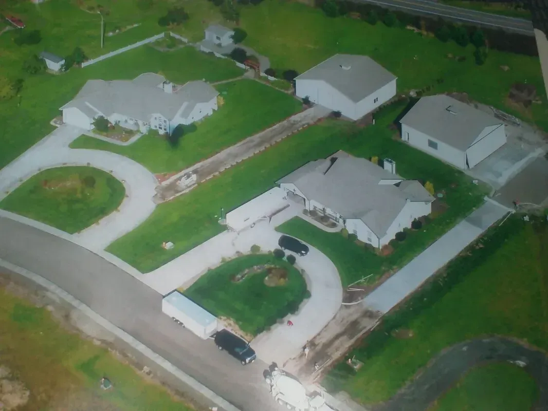 View of large residential concrete driveways and airplane approach with circular turnaround and clean finish